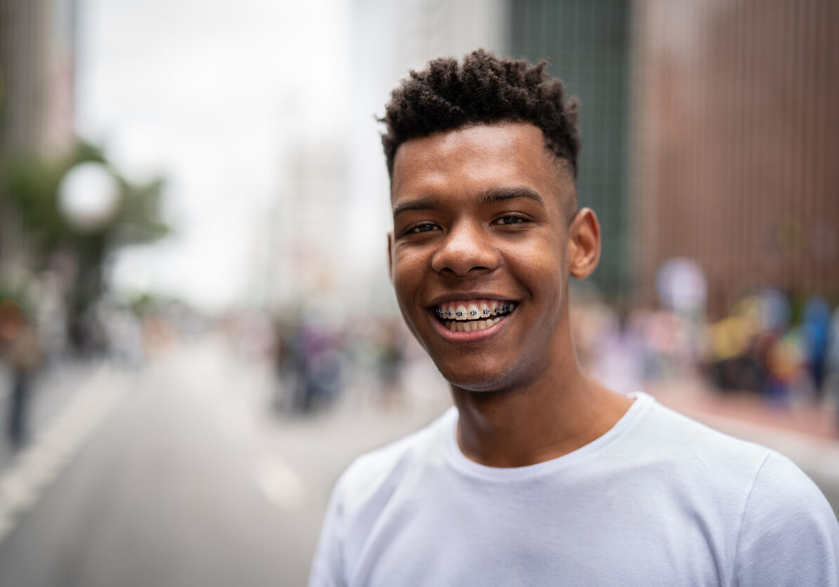Young black man looking at camera and smiling.